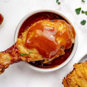 overhead shot of drumstick over bowl of nashville hot sauce