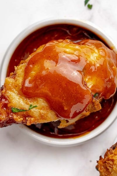 overhead shot of drumstick over bowl of nashville hot sauce