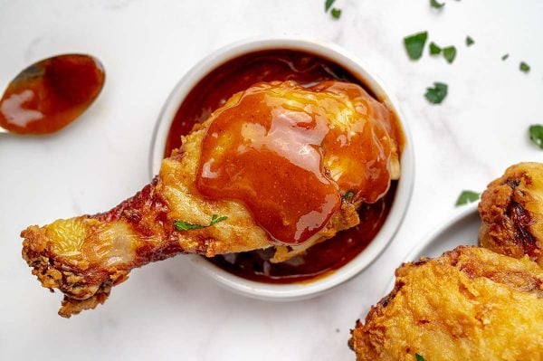 overhead shot of drumstick over bowl of nashville hot sauce