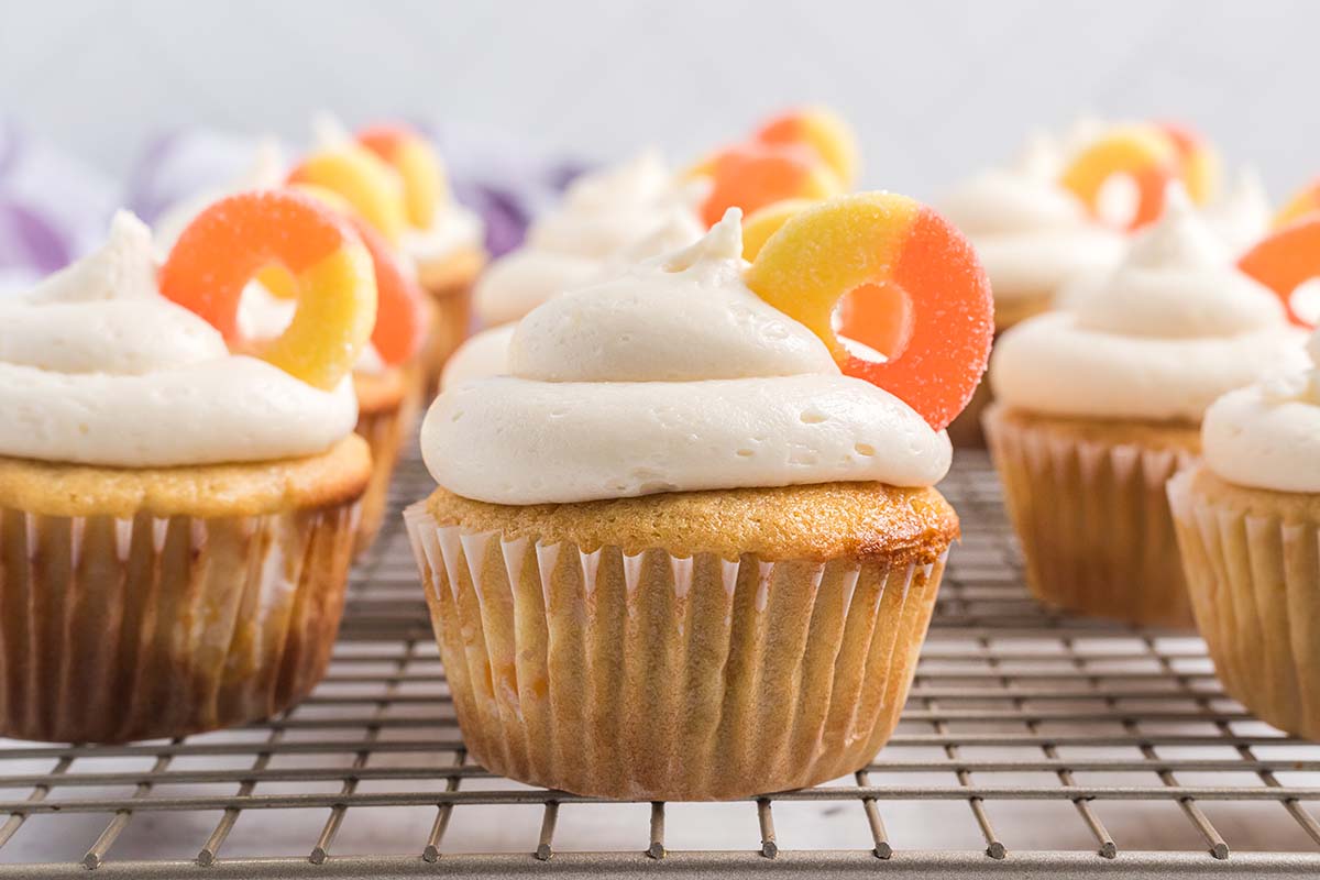 peach cupcakes on a wire cooling rack