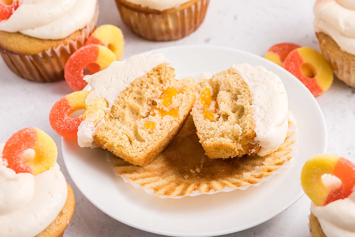 peach cupcake cut in half to show chopped peaches inside