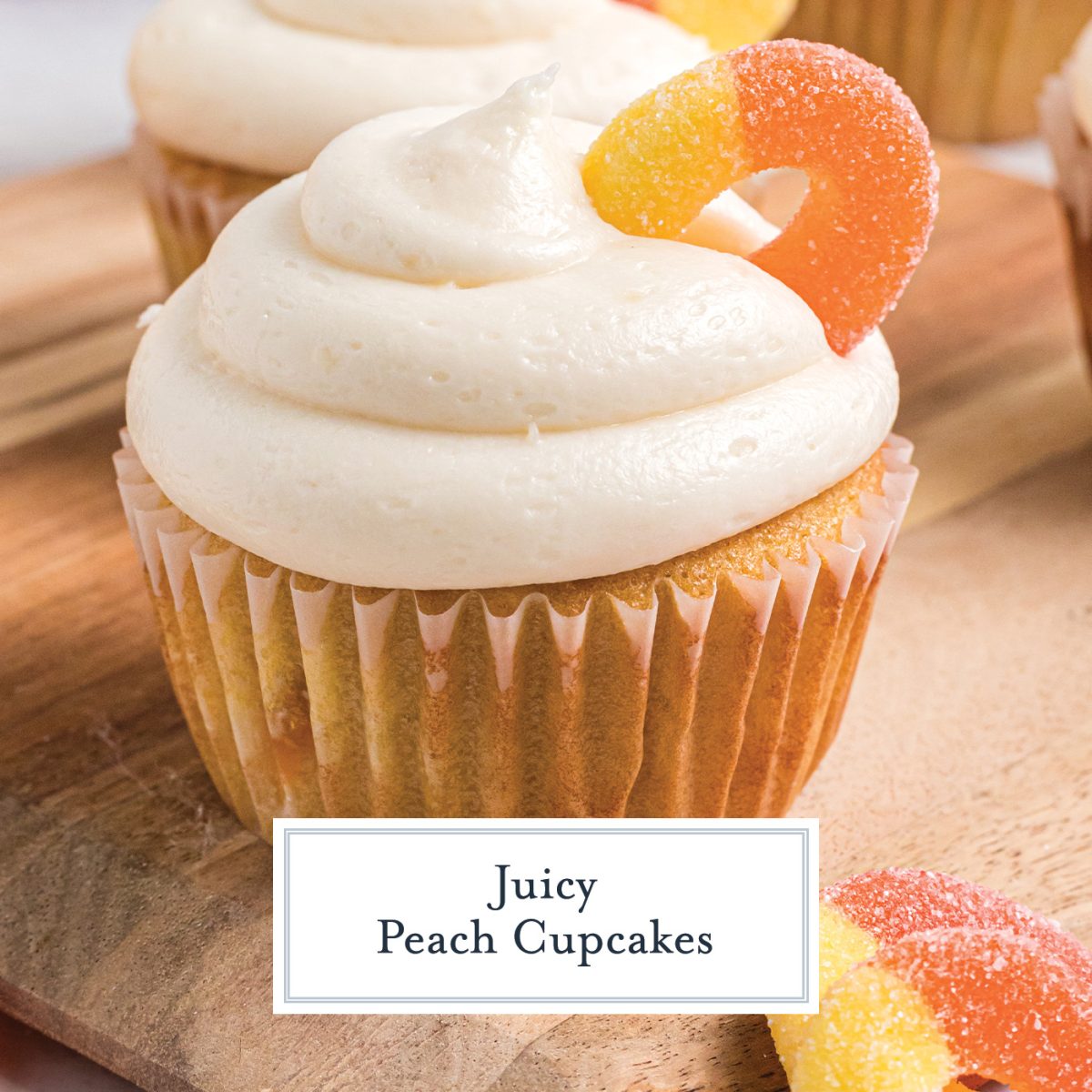 close up of peach cupcake with cream cheese frosting and a peach ring