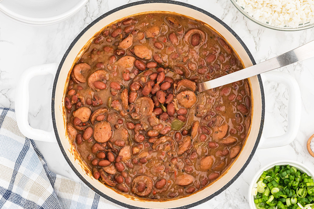 overhead pot of red beans and rice with a serving spoon