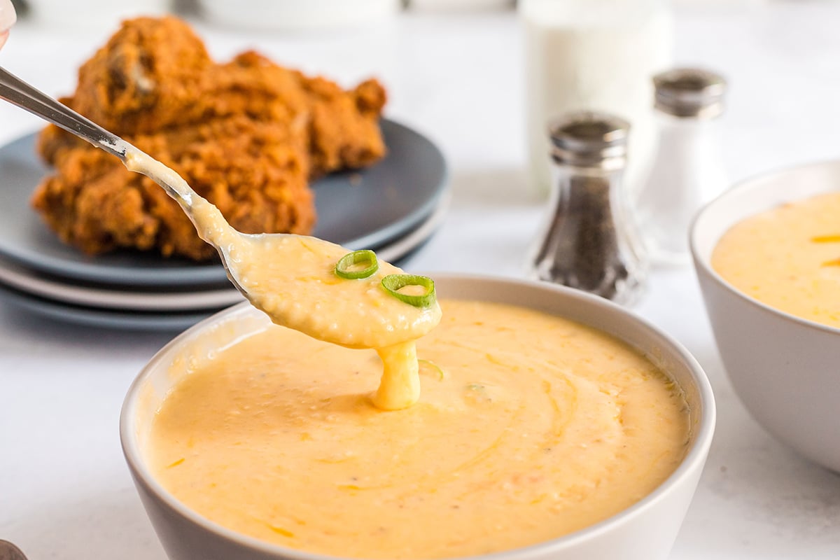 spoon dipping into bowl of creamy grits