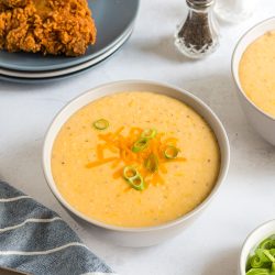 bowl of creamy cheddar cheese grits topped with green onions