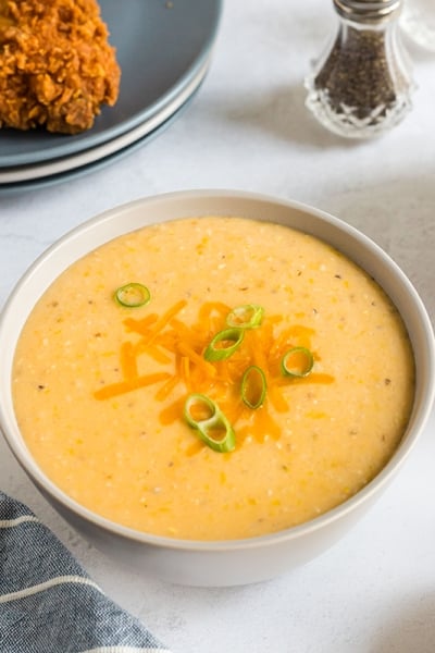 bowl of creamy cheddar cheese grits topped with green onions