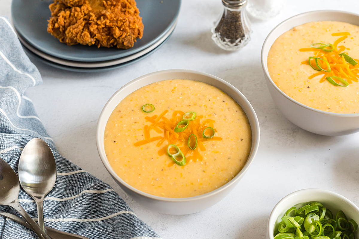 bowl of creamy cheddar cheese grits topped with green onions