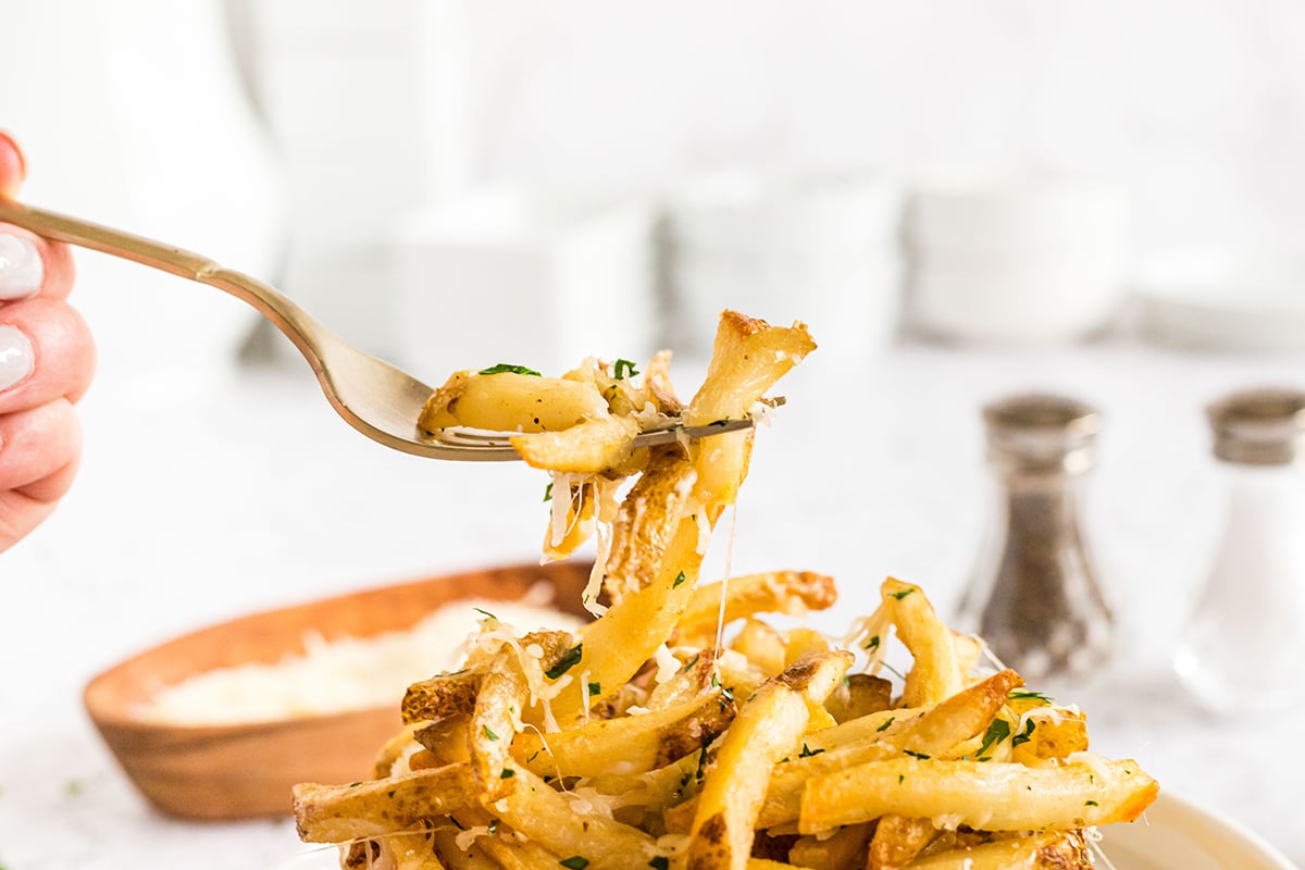 fork digging into cheesy garlic fries