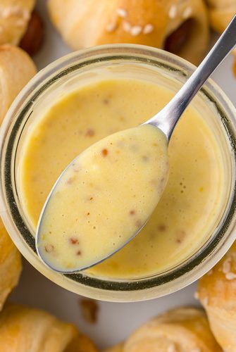 spoon dipping into honey mustard sauce
