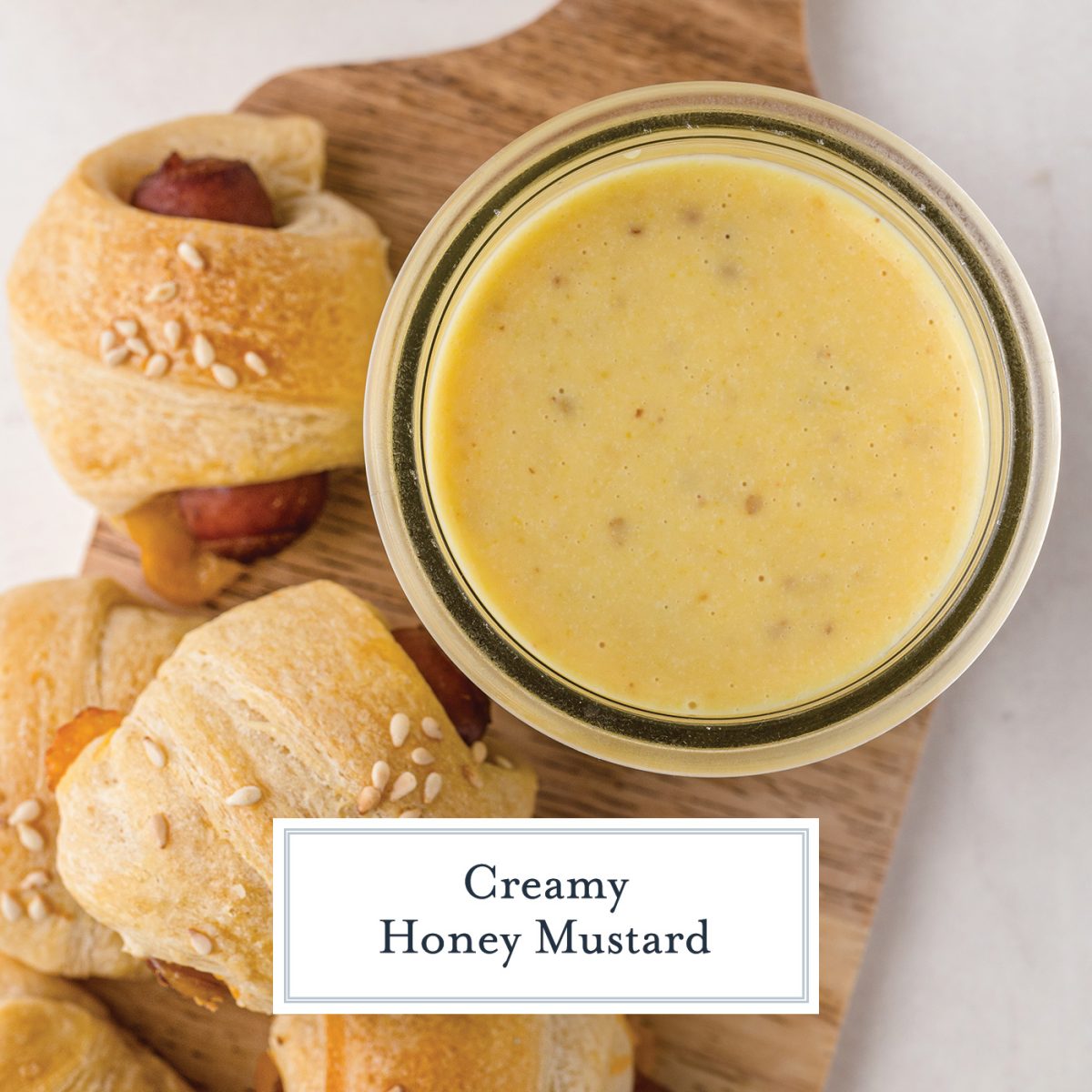 overhead of honey mustard sauce with pigs in a blanket 