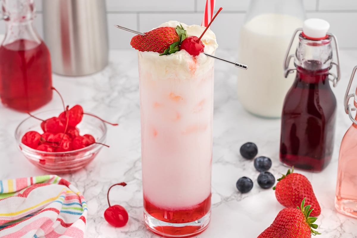 italian cream soda garnished with a strawberry and cherry 