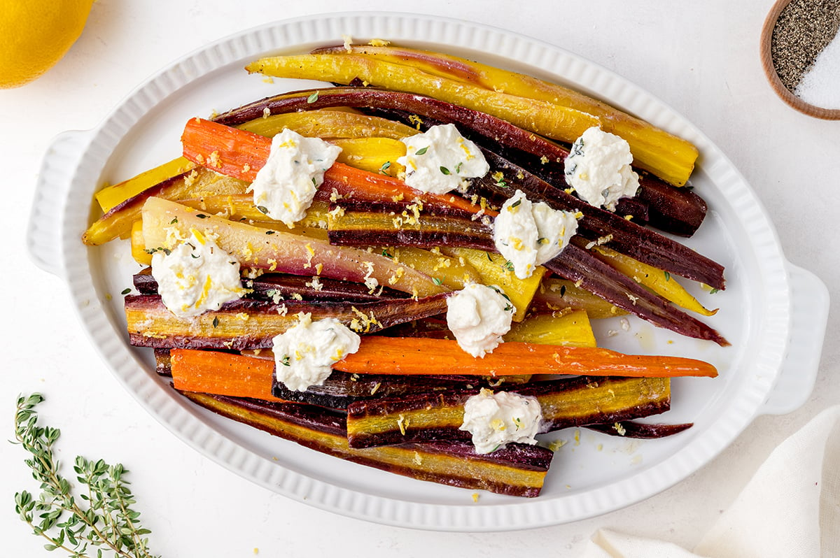 overhead platter of oven roasted whole carrots with white sauce