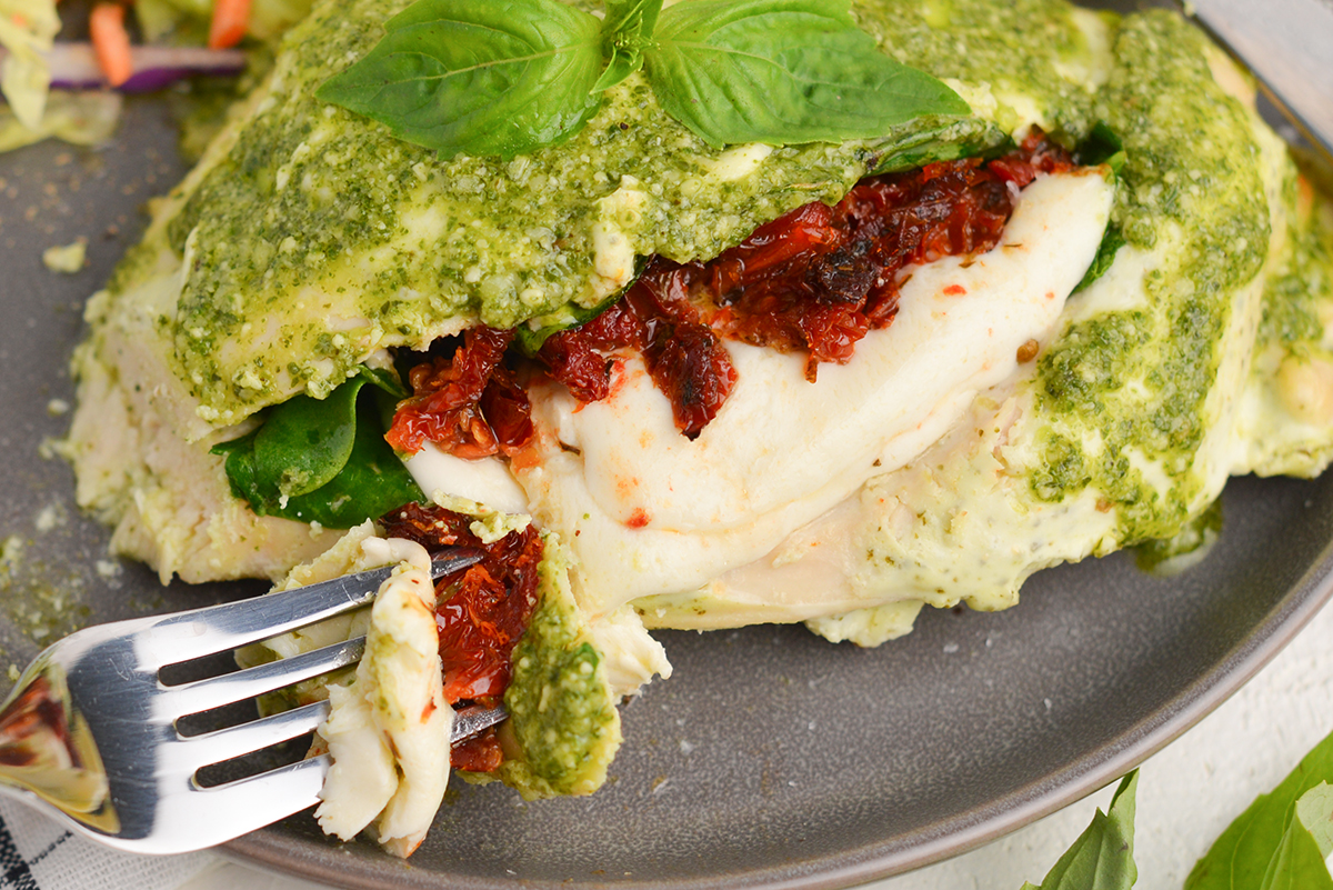 bite of pesto stuffed chicken with tomatoes and cheese 