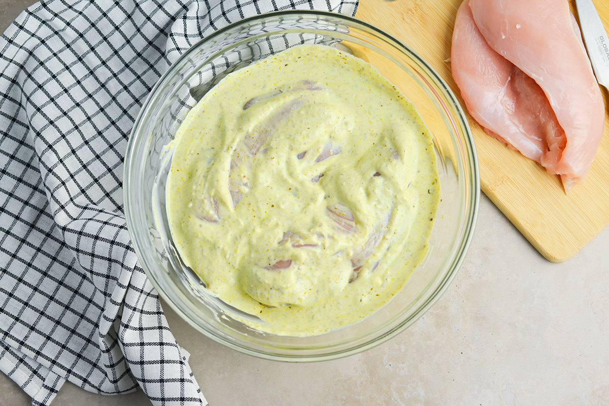 overhead of yogurt pesto marinade with chicken breasts