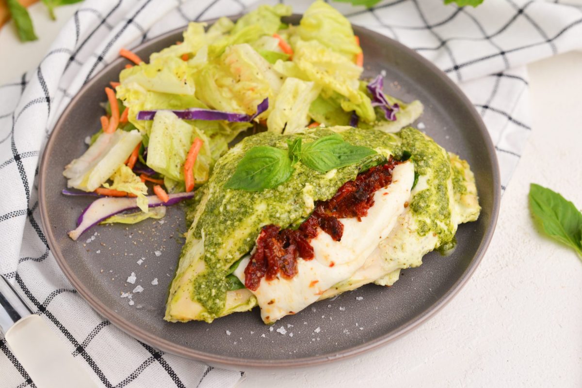 overhead angle of stuffed chicken breast with salad on serving plate 