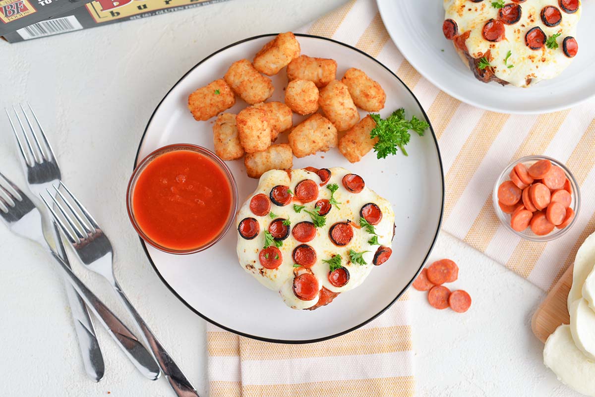 overhead of pizza sandwich with dipping sauce and tater tots 