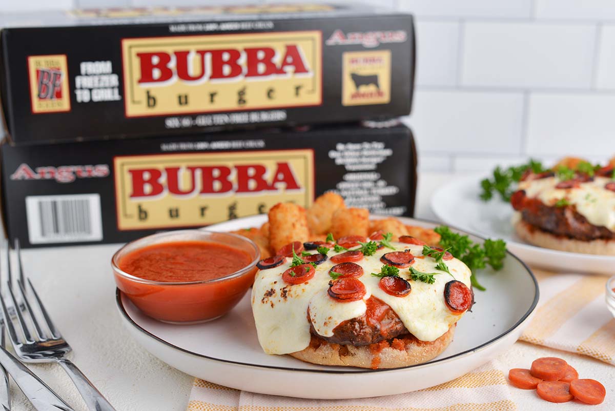 angle view of open face pizza sandwich with bubba burger boxes in the background 