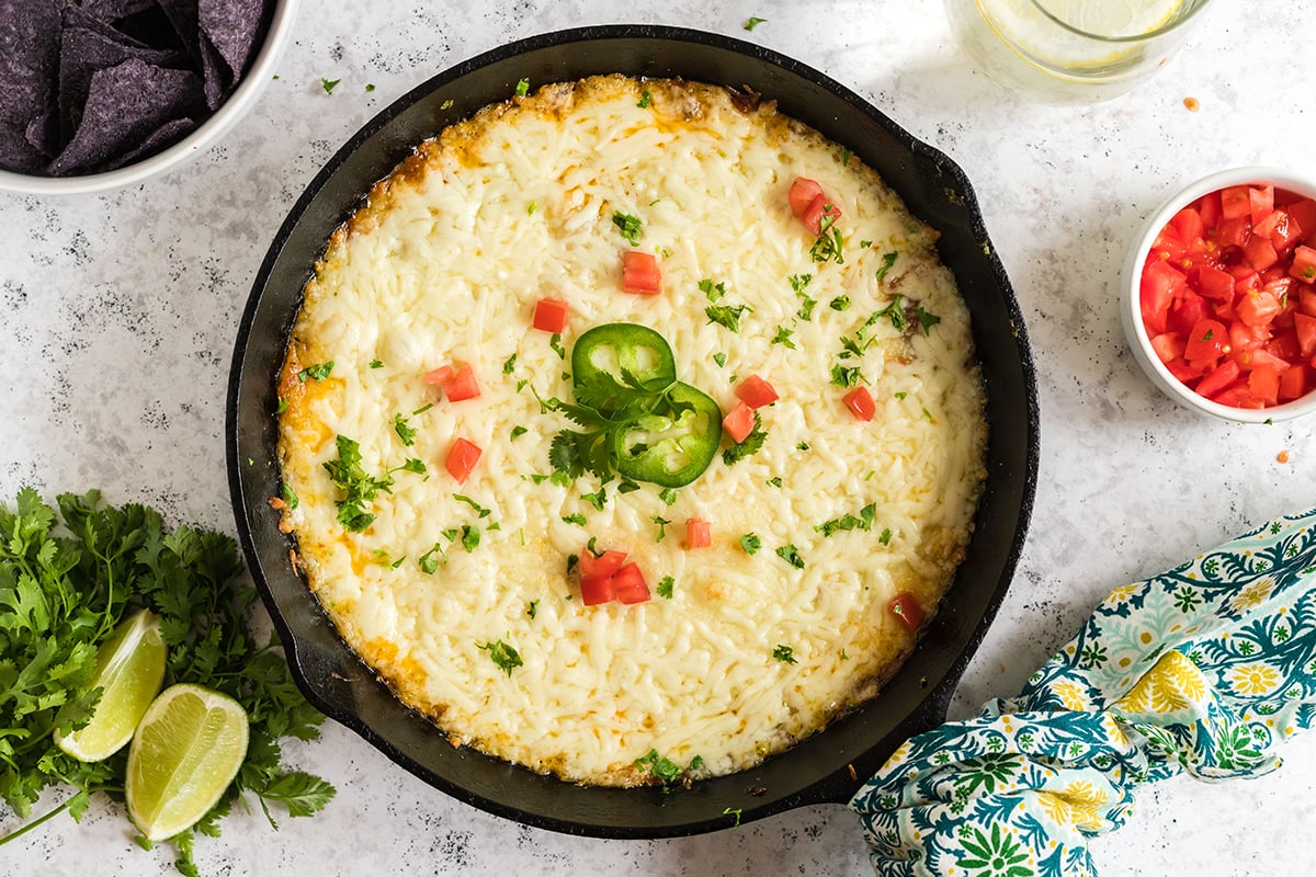 overhead shot of queso fundido topped with jalapenos and cilantro