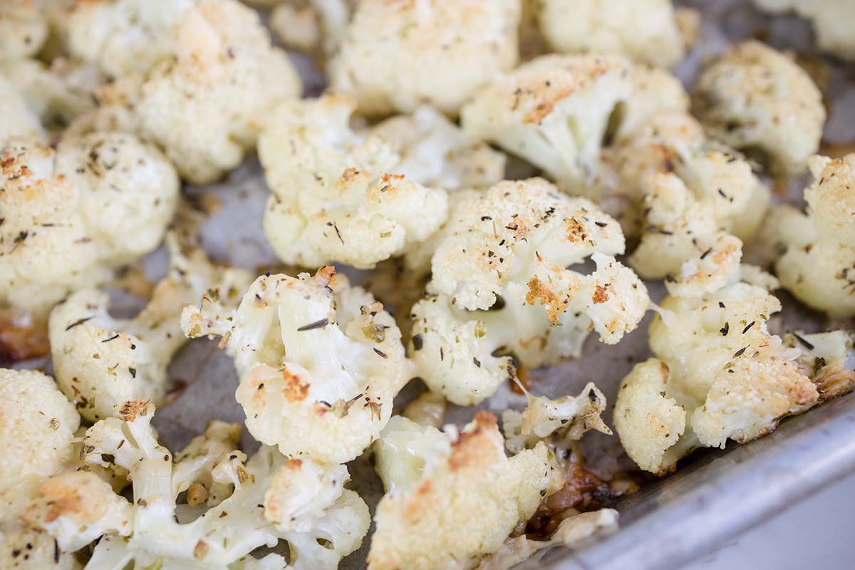 close up of roasted cauliflower florets on a baking sheet 