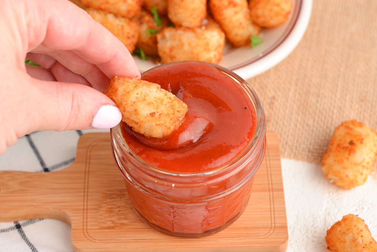 tater tot dipping into hot ketchup 