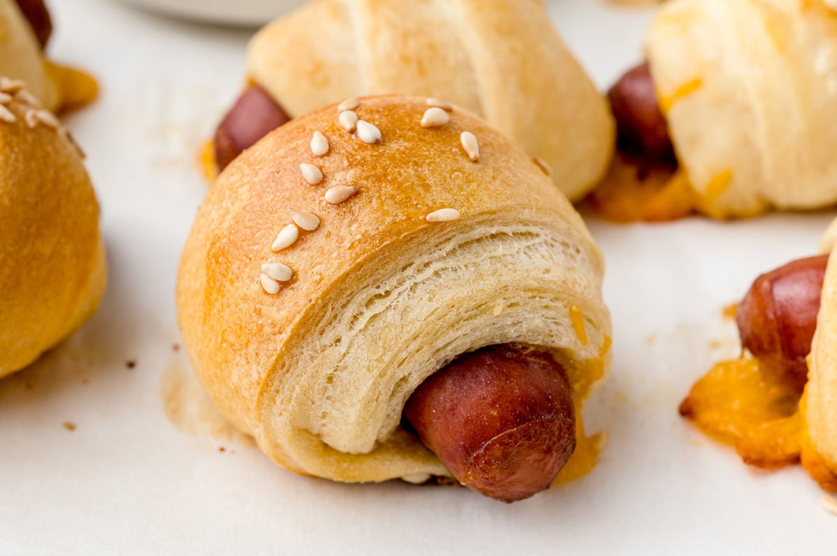 close up of pig in a blanket with sesame seeds 