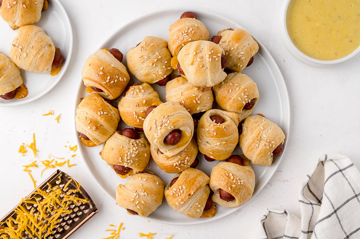 pigs in a blanket on a serving platter with honey mustard sauce 