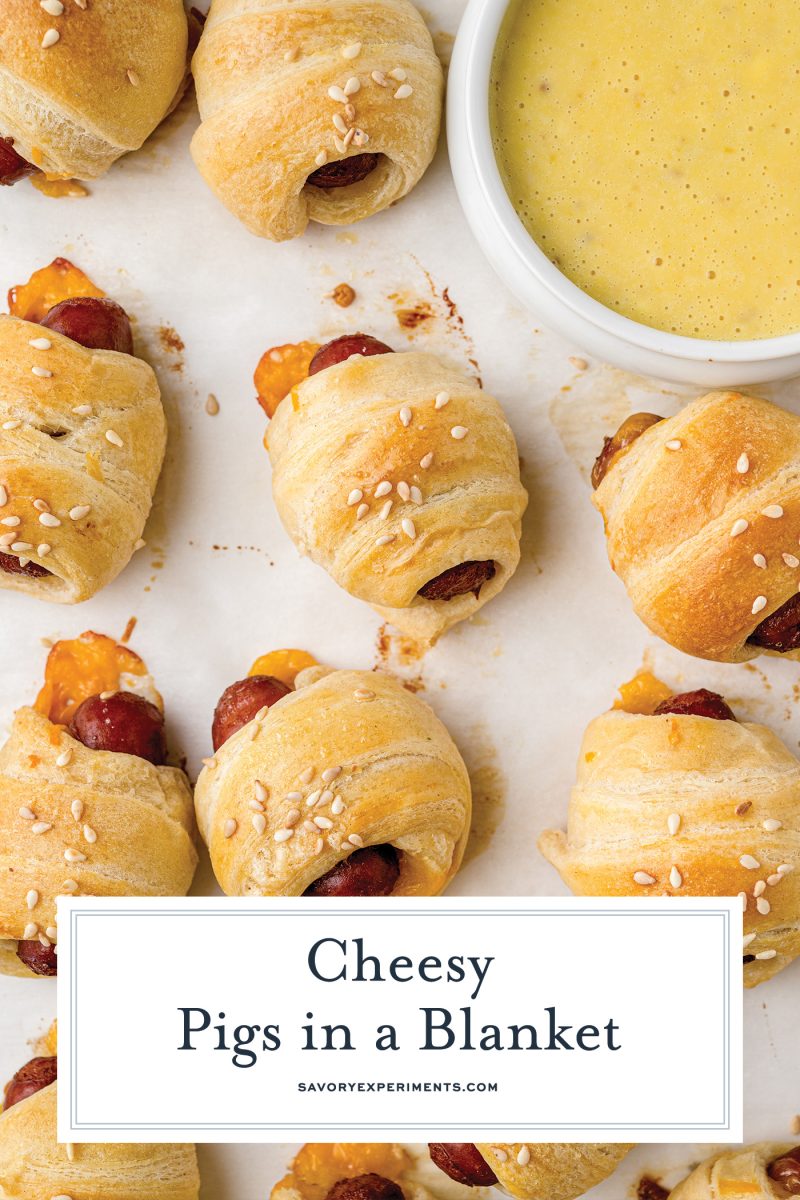 overhead of cheesy pis in a blanket on a parchment lined baking sheet 