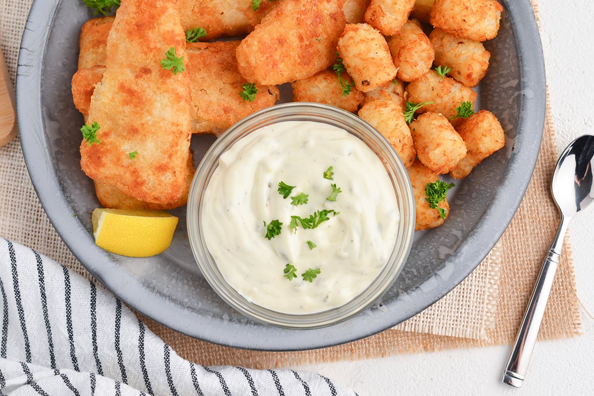 overhead shot of bowl of tartar sauce on plate of fish