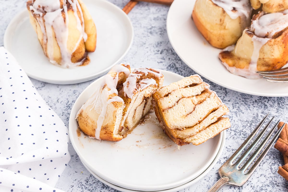 cinnamon roll cut in half on a white plate