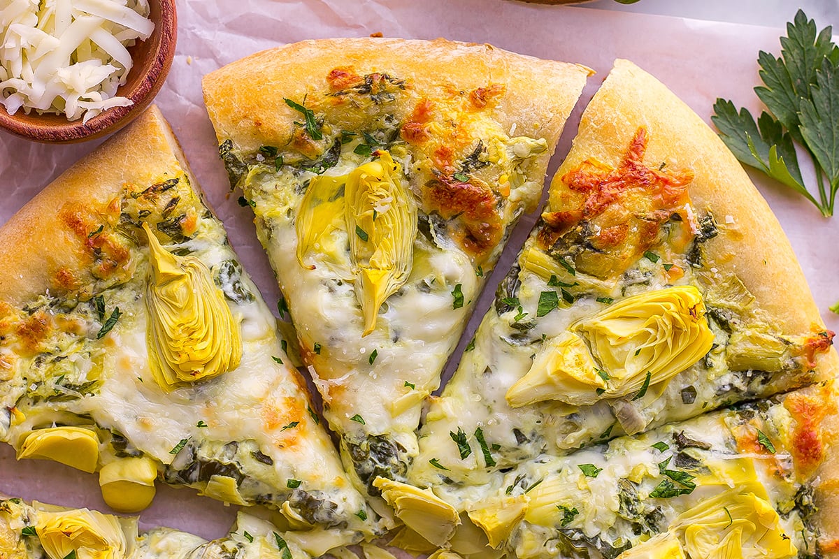 spinach artichoke dip pizza cut into slices