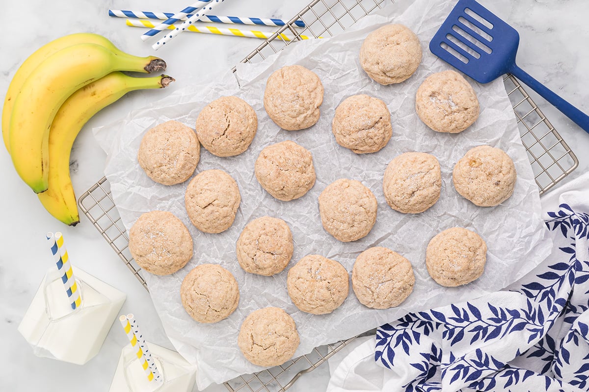 banana sugar cookies on a cooling rack with fresh bananas 