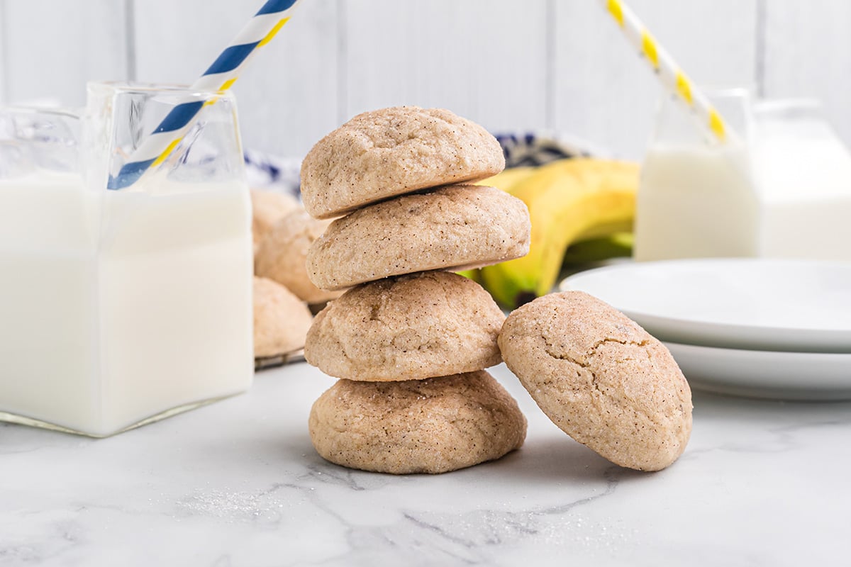 stack of cookies with cups of milk 