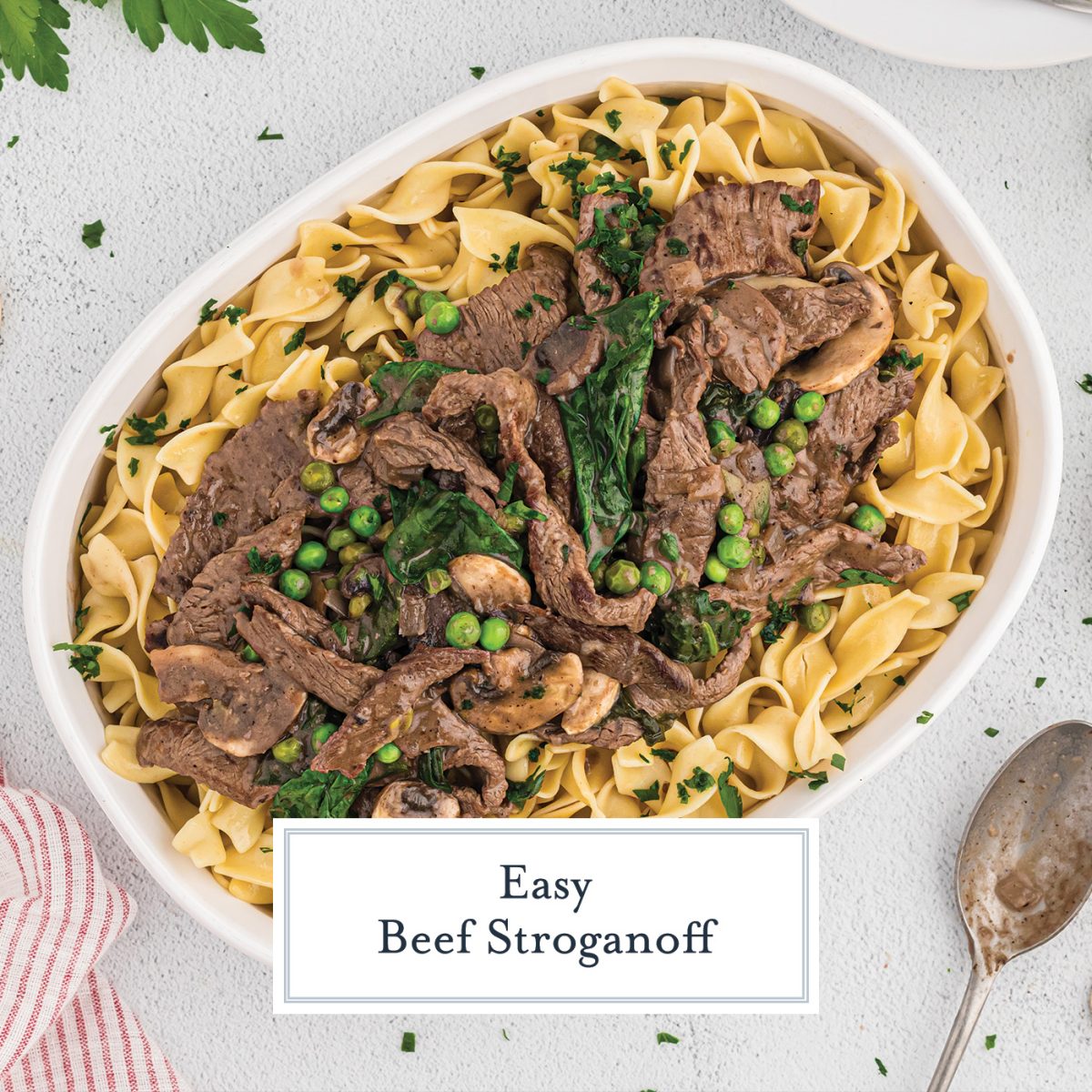 large serving dish with buttered noodles topped with beef stroganoff 