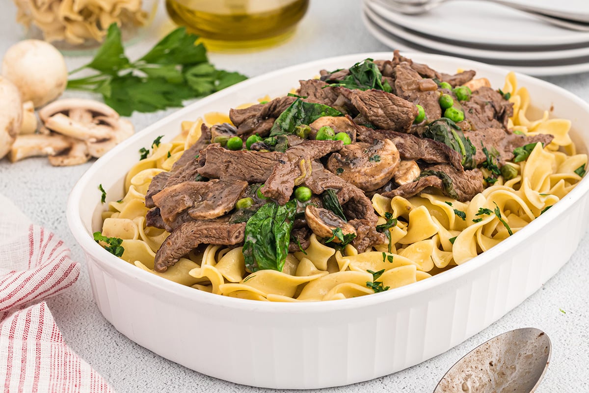 angle view of serving dish of stroganoff with a serving spoon 