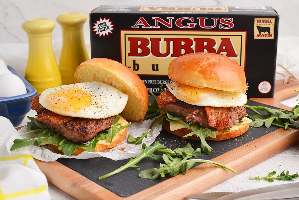 two burgers with eggs and a bubba burger box in the background 
