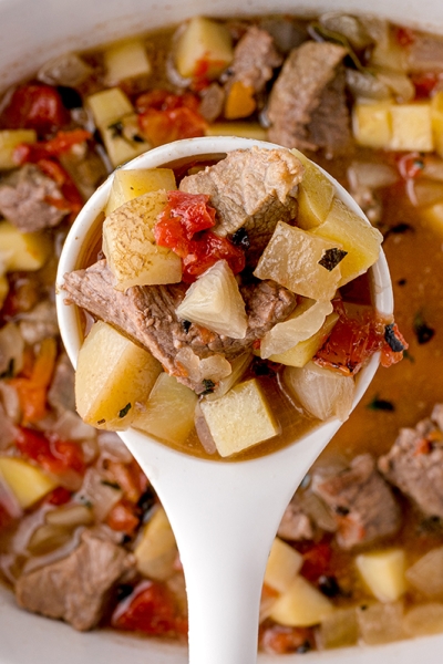 overhead shot of slow cooker beef stew in a ladle