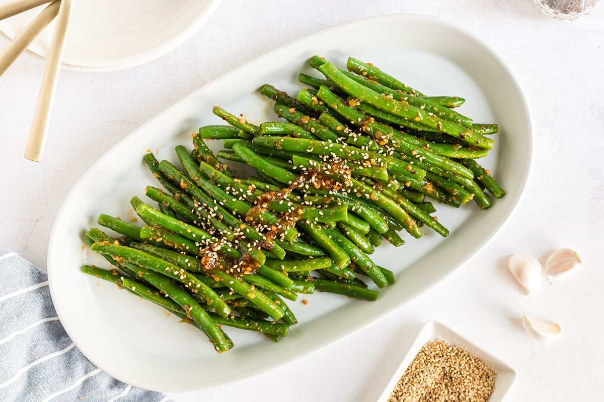 overhead shot of pf changs green beans on a white platter