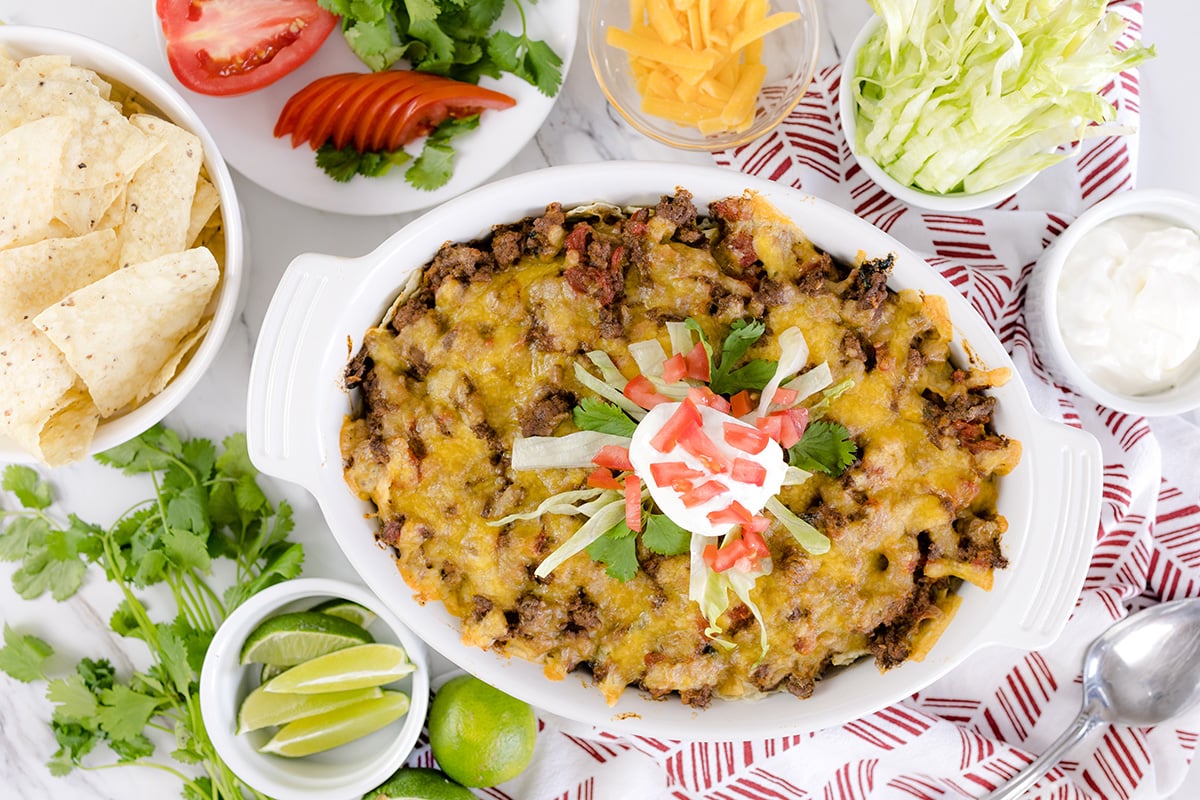 overhead of taco bake casserole surrounded by topping ideas 