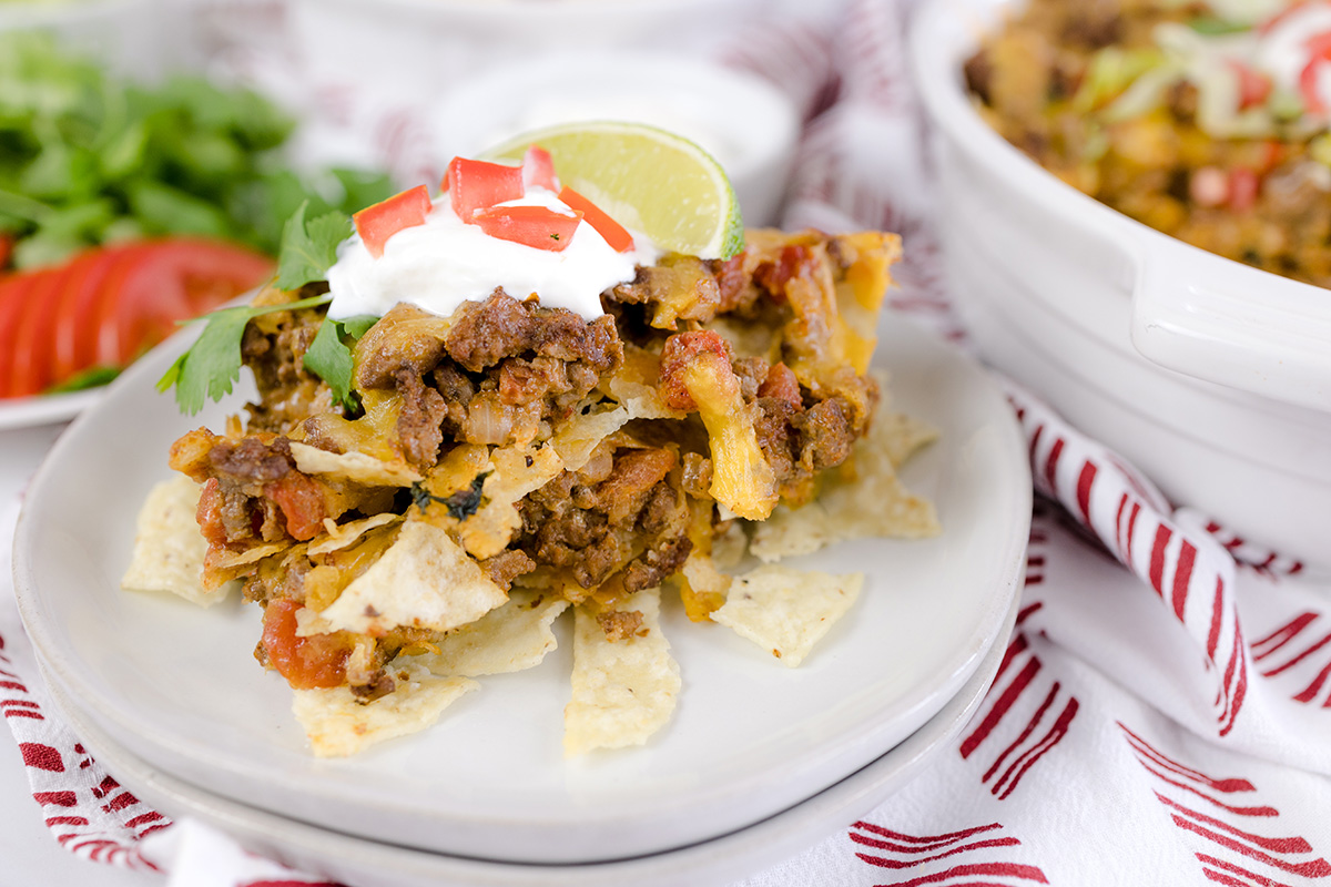 close up of scoop of taco casserole on a white plate 