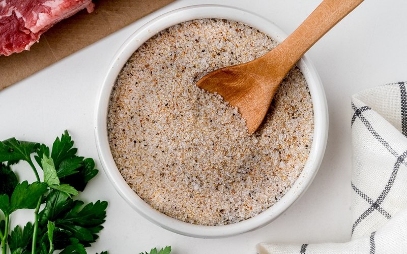 wooden spoon in bowl of steak seasoning