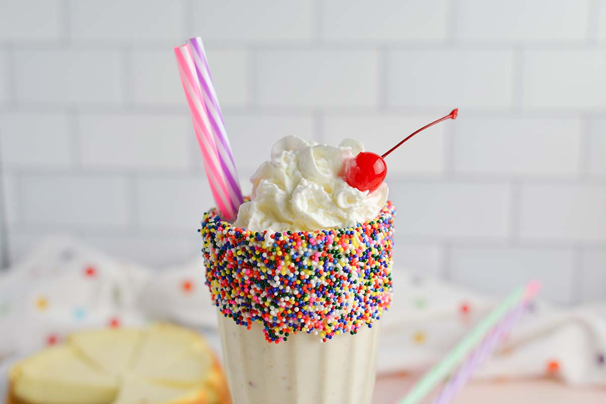 malt glass with sprinkles, whipped cream and a cherry 