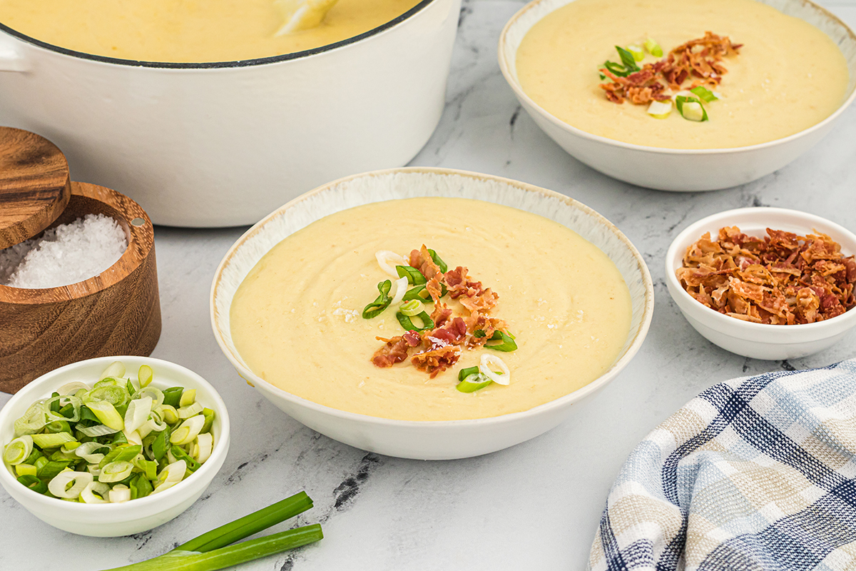 bowl of leek and potato soup topped with bacon and scallions