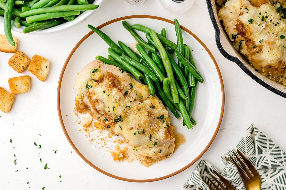 overhead shot of french onion chicken bake on a plate with green beans