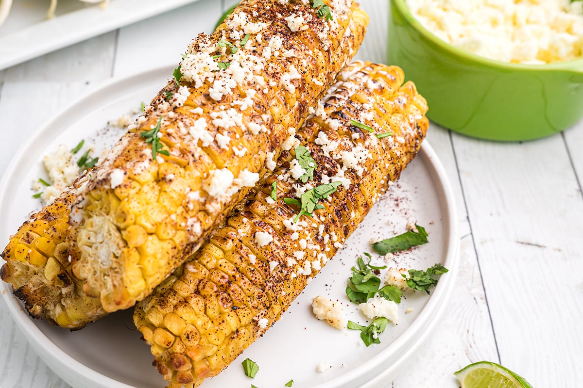 three ears of mexican street corn on a plate