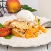 straight on shot of peach dump cake topped with ice cream