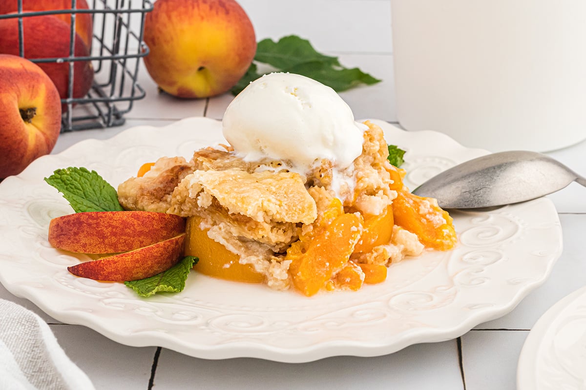 straight on shot of peach dump cake topped with ice cream