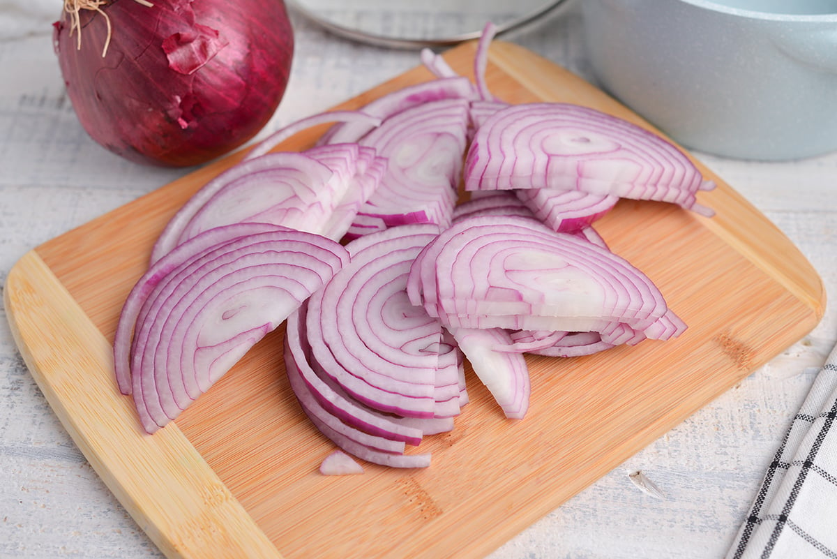 sliced red onion on a wood cutting board 