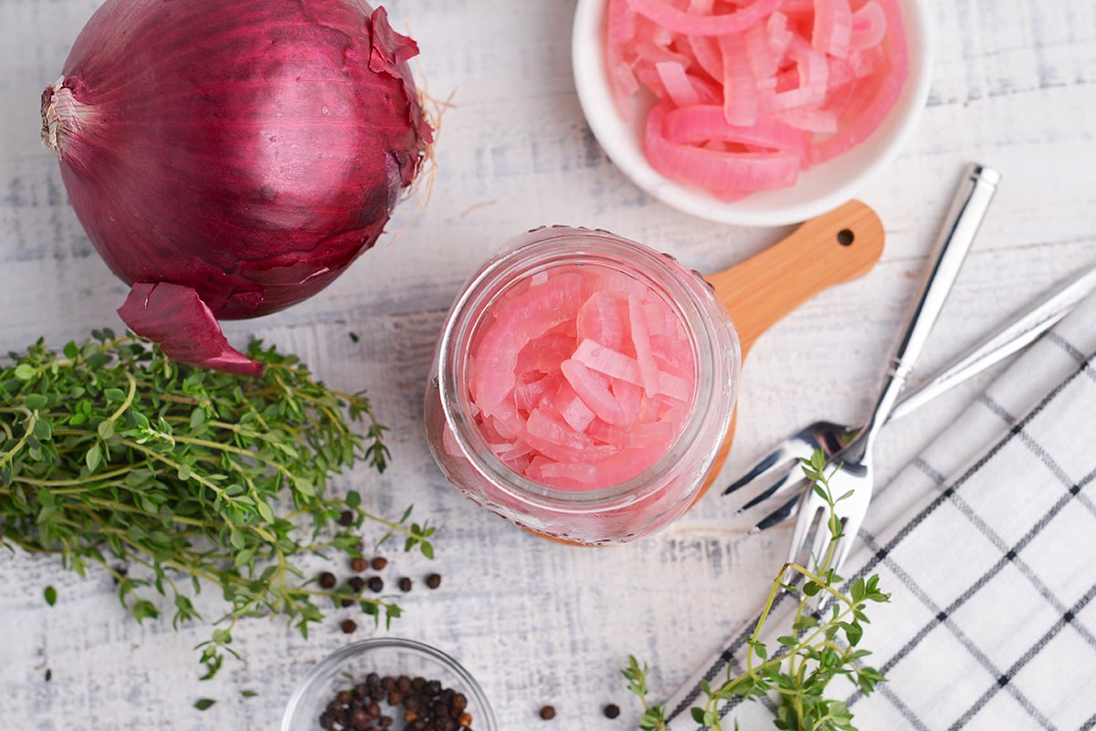 overhead of red onion in a glass jar 