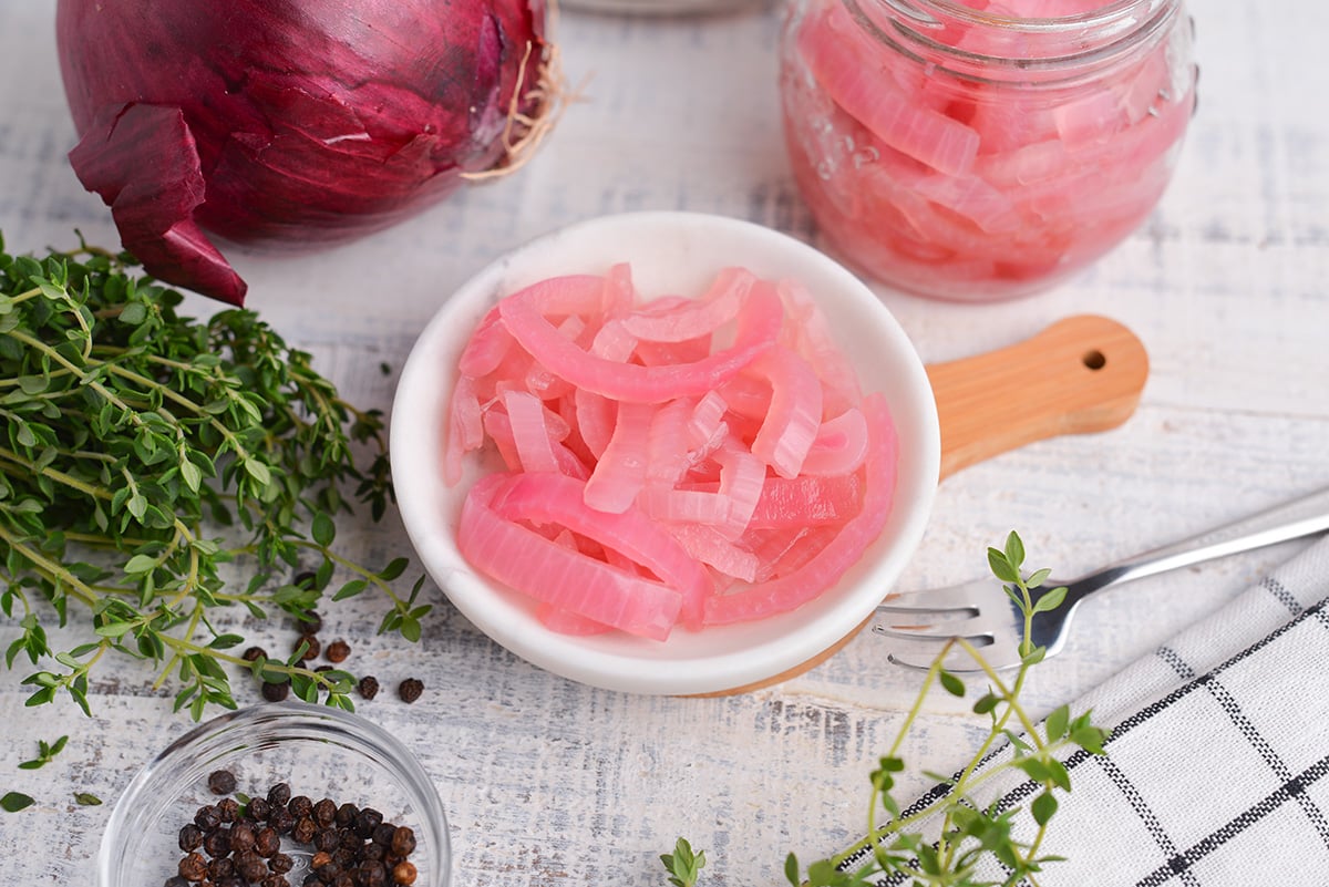 sliced pickled onions in a small white bowl  