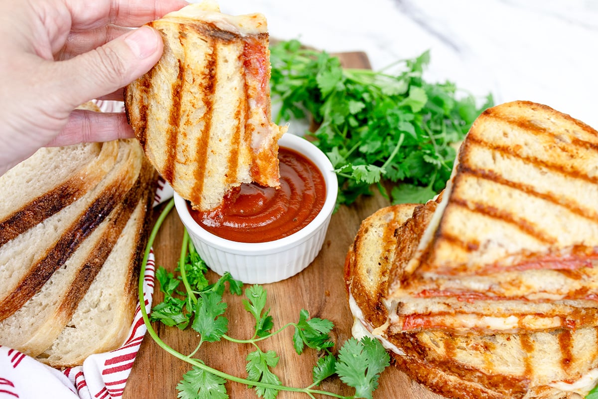 pizza sandwich dipping into marinara sauce